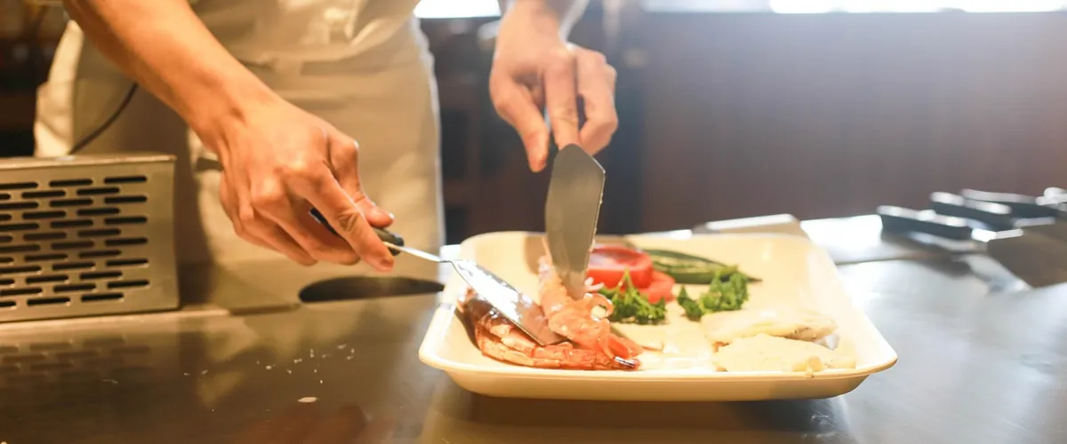A chef cooking in a busy restaurant kitchen, the hospitality business we help fill covers